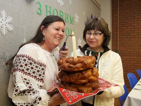 Linda Czyrka, left, and Lorraine Lazarenko-Santala light a candle for the kolach (Christmas bread) at Christmas Eve celebrations at the Ukrainian Seniors Centre in Sudbury, ON. on Sunday, January 6, 2013. Members of the centre enjoyed a holy supper, which featured 12 meatless dishes. JOHN LAPPA/THE SUDBURY STAR/QMI AGENCY