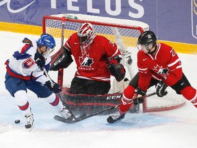 Canada's goalie Malcolm Subban (C) makes a save as teammate Dougie Hamilton defends against Slovakia's Michal Uhrik (L) during the third period of their preliminary round game during the world junior hockey championship in Ufa.  (REUTERS/Mark Blinch)