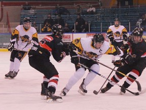 Simcoe Storm captain Connor Robinson squeezes between a pair of Aylmer Spitfires players at Talbot Gardens Sunday night. Simcoe won the game 6-1 and now sits in fourth place. (DANIEL R. PEARCE  Simcoe Reformer)