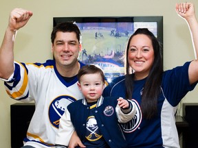 Hockey fans Eric Hanssen, left to right, Oscar Hanssen, 2, and Andrea Hanssen, pose for a photo in their Edmonton home after it was announced the lockout was over on Sunday, Jan. 6, 2013. Amber Bracken/Edmonton Sun/QMI Agency
