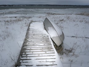 A boat and dock lie high and dry on the shore of Owen Sound Bay. Lower water levels, shoreline structures and lack of ice cover are among the factors stressing the Great Lakes, according to a new study project by a group of researchers.