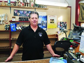Chris Lafreniere, owner of Racer's Edge, stands at his counter on his last day in business at his familiar Delhi Street location. RONALD ZAJAC The Recorder and Times