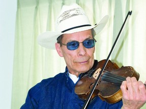 Phil Lethbridge plays a tune on his 129-year-old practice fiddle in his home out side Pincher Creek.