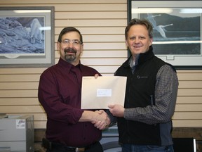 Stan Burkholder (left), chairman of the Fairview Health Complex Foundation, receiving a $1,000 check from Brent Clair (right), regional land representative for TransCanada Pipeline. The presentation took place at the offices of the Fairview Post on Friday, Jan. 4, 2013. (Simon Arseneau/Fairview Post)