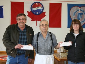 John Thompson (left) operations manager of Dunvegan North Oilfield Services ULC and Billie Keddie (right) educational assistant substitute at E.E. Oliver school receiving checks from Sam Halabi (middle) owner/manager of restaurant Grandma's Pizza. The presentation took place on Friday, Jan. 4, 2013, at Grandma's Pizza. (Simon Arseneau/Fairview Post)