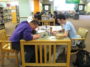 London?s libraries are a gathering place for a wide range of people, including (from left to right) Central secondary school students Ee-Shan Lim, Andason Cen (rear left) and Andrew Carmichael, who were doing homework Tuesday afternoon at the downtown Central Library. (IAN GILLESPIE, The London Free Press)