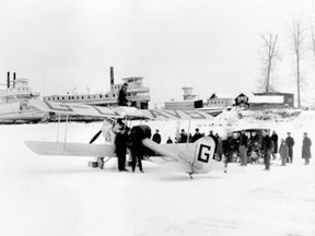 77.830.58.09 
Wop May and Vic Horner in Peace River, Jan. 3, 1929, n their return to Edmonton following their Mercy Flight to Fort Vermilion. Note: the plane has wheels not skis. In the background of the photograph (l-r) S. S. D.A. Thomas, S. S. Athabasca River, which by at least one account was abandoned, and S. S. Weenusk.