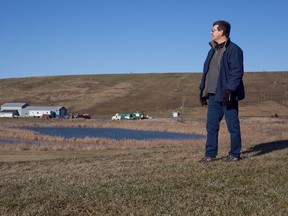 Mike Bossio, chair of the Concerned Citizens Committee of Tyendinaga and Environs, stands in front of the closed Richmond landfill in the distance, just north west of Napanee, Ont. - FILE/QMI AGENCY
