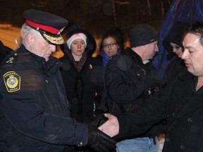 Aamjiwnaang First Nation Chief Chris Plain, right, shakes hands with Sarnia Police Chief Phil Nelson prior to a celebratory ceremony at the CN rail blockade on Williams Drive recently. (PAUL OWEN, The Observer)