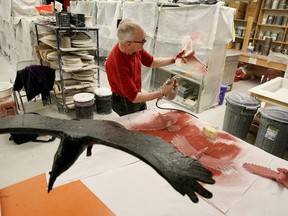 Ceramics artist Keith Campbell, shown Friday at the Canadore College pottery studio, sprays clay birds with red glaze that turns black in the kiln for his one-man travelling exhibition Journey through the Past opening Saturday at the Sudbury Art Gallery before it moves to southwestern Ontario. (MARIA CALABRESE The Nugget)