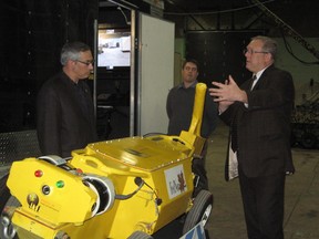 Greg Baiden takes FedNor Minister Tony Clement on a tour of Penguin Automated Systems Inc. on Wednesday. (Carol Mulligan The Sudbury Star)