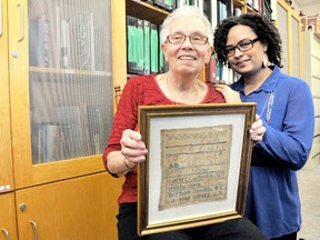 Gwen Robinson, local black historian, left, holds the Harriet Smith Sampler, one of the many items she collected over several decades researching local black history. Blair Newby, executive director, right, Chatham-Kent Black Mecca Museum, honoured the founder of the museum, by renaming the archive room the Gwendolyn Robinson Research Centre. (DIANA MARTIN, The Chatham Daily News)
