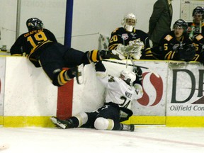 The games between the Saints and Grande Prairie are always rough and tumble affairs as Tim Nolte of the Grove and Marc-Etienne Drapeau battle along the boards during a game from early December in the Grove. Over the weekend in GP, the teams split their two games.