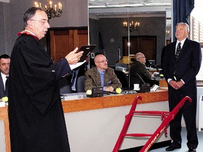 Then Elgin county Warden, Dave Mennill, left, reads a plaque after accepting an historic plow donated to the county by John Wise, right, a former federal agriculture minister and dairy farmer. The plow was restored after being bought by Central Elgin Mayor Bill Walters and presented to Wise at the 2010 International Plowing Match. Wise died Wednesday in London at the age of 77.