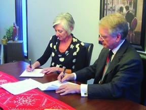 Kathy Chapman and Barney Christianson sign the papers to create The John and Kathy Chapman Family Fund, Thursday at Chapman's home. The $50,000 fund will be undesignated to allow the Community Foundation of Portage and District (CFPD) to address the community's changing needs. (ROBIN DUDGEON/PORTAGE DAILY GRAPHIC/QMI AGENCY)