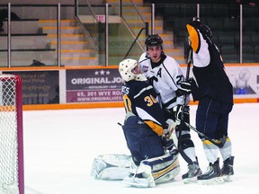 Canmore Eagles goalie Cam Barnes gets a face full of Sherwood Park assistant captain Danny Smith as an Eagle defenceman tries to pry them apart during play on Sunday Dec. 16, 2012. Trent Wilkie/Sherwood Park News/QMI Agency