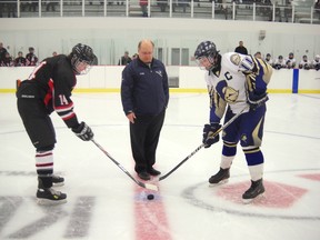 Al Greber drops the ceremonial face-off between Peace River captain Zach Schofield (left) and GP captain Riley Cook, prior to the first-ever minor hockey game at the new County of Grande Prairie Sportsplex. (Submitted)