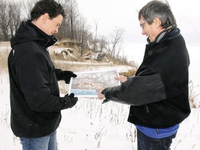 Peter Dutchak, left, deputy director of engineering services for Elgin county, and Clayton Watters, director, point out on a topographical map a severe section of erosion bordering Dexter Line, two km west of Port Bruce. Times-Journal file photo