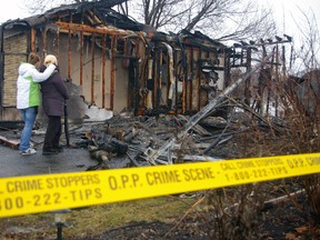 Sisters Lia and Amanda Campbell look over ruin of family home which burned early Friday in Central Elgin on Lawton St. No one was hurt -- the family had recently moved -- but the home was destroyed. Cause of the fire was under investigation. (Eric Bunnell Times-Journal)