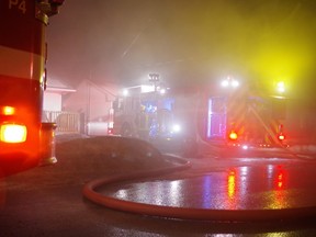 Smoke fills the air as firefighters battle a garage fire at a home on Glenholme Drive on Friday night. Witnesses on the scene said no one appeared to have been injured in the blaze.