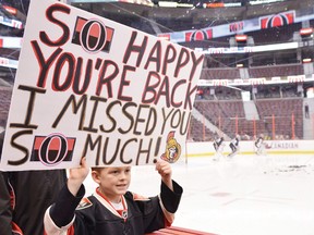 Brighton Compton, age 8, holds up a sign during the Ottawa Senators practice on Sunday.
QMI Agency/MATTHEW USHERWOOD