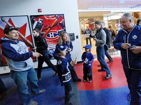 If the Leafs hope to make amends with fans following the lockout, coach Randy Carlyle seems to be on top of it, signing autographs for an excited family at training camp yesterday at the MasterCard Centre. (MICHAEL PEAKE/TORONTO SUN)