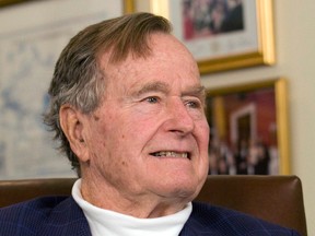 Former U.S. President George H.W. Bush listens to Republican presidential candidate Mitt Romney in Houston, Texas, in this March 29, 2012 file photo. (REUTERS/Donna Carson/Files)