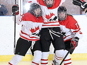 Sherwood Park’s Karly Heffernan, centre, is congratulated by teammates after scoring 58 seconds into overtime to give Canada gold at the U-18 Women’s Worlds. Photo supplied
