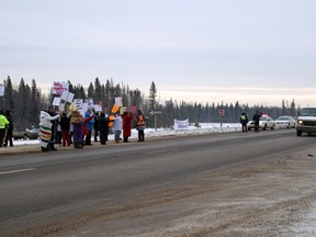 Protesters with the Idle No More movement pose next to Highway 63 Thursday afternoon. Local RCMP observed nearby without interfering. VINCENT MCDERMOTT/TODAY STAFF