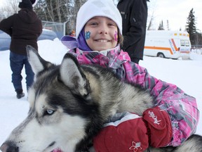 Faith Covey, 8, cuddles up to Peaks, a Siberian husky sled dog. As part of the Porcupine/South Porcupine Winter Carnival, North Bark Dog Tours offered dog sled rides (file photo from 2011 winter carnival).