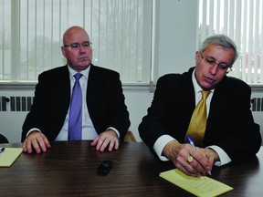 Ontario Progressive Conservative MPP Vic Fedeli, right, illustrates the process of calculating an energy bill while Leeds-Grenville MPP Steve Clark listens during an event at Clark's constituency office in this January 2013 file photo.