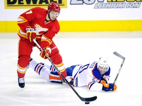 T.J. Brodie, left, of Chatham is at the Calgary Flames' training camp after playing with the AHL's Abbotsford Heat during the NHL lockout. He is shown stealing the puck from Edmonton Oilers' Eric Belanger on Dec. 10, 2011, in Calgary. (TODD KOROL/Reuters)