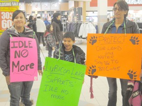 Logan Clow/R-G
Participants crowded the Riverdrive Mall in Peace River on Saturday (January 12) afternoon for a peaceful flash mob, otherwise known as the Idle No More movement in response to Bill C-45, which supporters say denigrates First Nation treaty rights. Pictured, Sherri Laboucan (left), Travis Laboucan Whitehead (middle) and Vera Laboucan (right) display some of signs they brought to the flash mob.