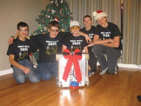 Members of the SWAT Bots robotics team, from left, Kyle Storrier, Gavin Roberts, Sam Allen, Josh Roberts and Steven Lipp, pose with their robot, ‘Chuck.’ The team won the national FTC championship on Jan. 12.