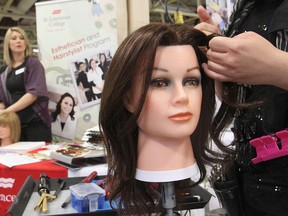 Lacey McGinnis, left, looks on during a display by the hairstyling course at St. Lawrence College at Wednesday's Trading Up event at the Portsmouth Olympic Harbour. The event, held by KEYS Job Centre, brought together a variety of skilled and professional trades to give students and the public ideas for possible careers. (Michael Lea The Whig-Standard)
