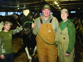Dairy farmers Chris and Brianne Brown and farmhand Jena Brown (left) pose with Patsy, one of the farm’s dairy cows.     ROB MOOY - KINGSTON THIS WEEK