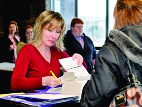 Shelley Fenlong, an Employment and Education Centre employee, looks at a resume during the Barley Mow job fair on Wednesday. ALANAH DUFFY The Recorder and Times