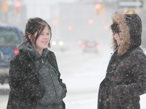 Friends Teagan Odber, left and Treasure Langevin keep warm in the brisk -15C elements and snow squalls on Thursday. In the next 24-hours in Sault between 5 to 15cm of snow is anticipated to fall.