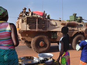 Villagers wave to the French military as they pass the town of Konobougou, Mali January 17, 2013. (REUTERS/Joe Penney)