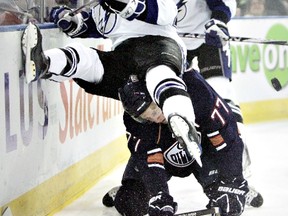 Edmonton Oilers player Tom Gilbert wipes Tampa Bay Lightning player James Wright off his back as they fight for the puck during pre-season NHL action at Rexall Place on Thursday, Sept. 23 2010, in Edmonton, Alta.  (AMBER BRACKEN/EDMONTON SUN)