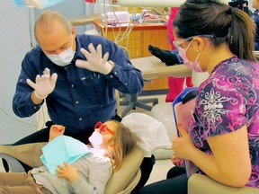 Callander dentist Mario Lemay with a dental hygiene student and their client during the Gift from the Heart event last year offering a free day of oral care at Canadore College. (SUBMITTED PHOTO)