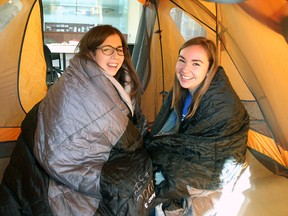 Queen's University students Corin De Sousa and Montana Hauser try out their sleeping bags inside the tent they have set up in the lobby of Stauffer Library for a week-long camp-in to raise money for literacy programs in Third World countries.
Michael Lea The Whig-Standard