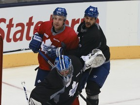 New Leafs defenceman Mark Fraser grabs hold of new Leafs winger Leo Komarov as holdover goalkeeper James Reimer makes a save during yesterday’s practice at the Air Canada Centre. The Leafs took off for Montreal later in the day, ready to face the Canadiens in the season-opening game for both sides tonight. (VERONICA HENRI/TORONTO SUN)