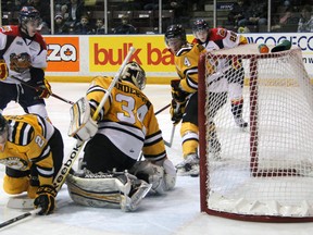 Craig Duininck (4) and J.P. Anderson (34) of the Sarnia Sting search for the puck in the crease after Erie Otter Connor McDavid (97) hit the post Friday, Jan. 18, 2013 at RBC Centre in Sarnia, Ont. (PAUL OWEN, The Observer)