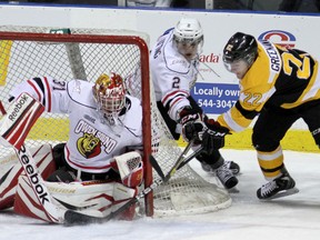 Kingston Frontenacs’ Darcy Greenaway tries a wraparound shot on Owen Sound Attack goalie Jordan Binnington as Keevin Cutting moves in to help during Ontario Hockey League action at the K-Rock Centre on Friday night. (Ian  MacAlpine/The Whig-Standard)