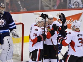 Winnipeg Jets goaltender Ondrej Pavelec (left) watches as Ottawa Senators' (left to right) Colin Greening, Chris Neil, Zack Smith, and Marc Methot celebrate a goal during the second period of their NHL hockey game in Winnipeg January 19, 2013. REUTERS/Fred Greenslade