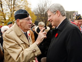 A war veteran speaks with Canada’s Prime Minister Stephen Harper following Remembrance Day ceremonies at the National War Memorial in Ottawa November 11, 2011.