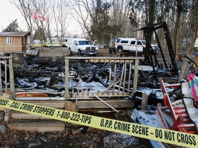 Investigators with the Ontario Fire Marshal Office, Tyendinaga Mohawk Police and the OPP are hoping to determine the cause of a cottage fire that left two people dead and one man fighting for his life at 180 Snookies Rd. in Shannonville on Friday night. (JEROME LESSARD QMI Agency )