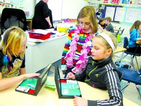 Grade 4 students Maddy Rose, left, and Jenna Enright, right, playing
Battleship while their friend Cassady Preston watches.