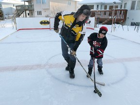 Ben Haegeman (left) and his son Dylan scrimmage on the hockey rink that he built in the back yard  of his home in West St. Paul, Man. Monday Jan. 21, 2013. (BRIAN DONOGH/WINNIPEG SUN)